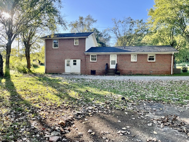 back of property featuring brick siding and crawl space