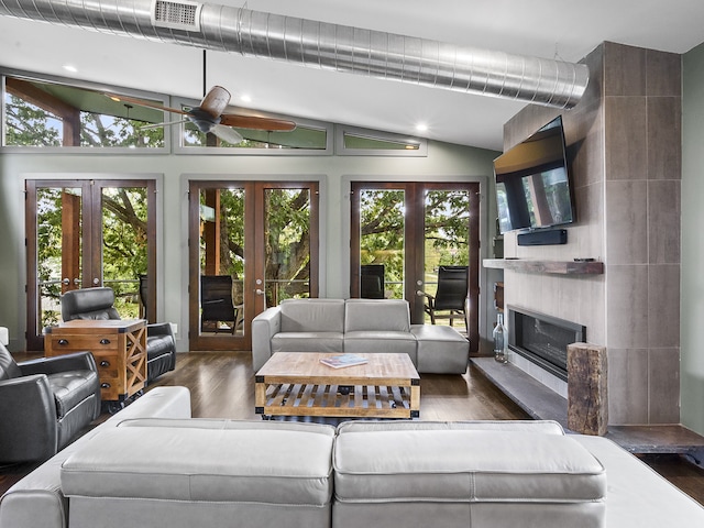 living room with a fireplace, vaulted ceiling, ceiling fan, dark hardwood / wood-style floors, and french doors