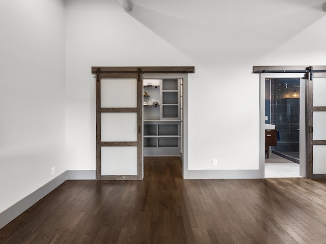 unfurnished room with a barn door and hardwood / wood-style flooring