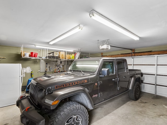 garage featuring white refrigerator and a garage door opener