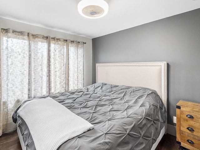 bedroom with dark wood-type flooring and multiple windows