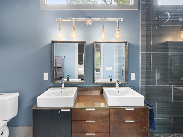 bathroom featuring vanity, toilet, and tiled shower