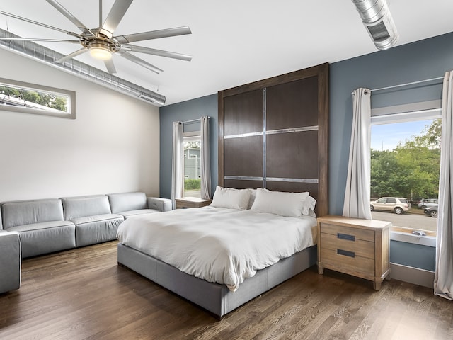 bedroom with multiple windows, ceiling fan, and dark hardwood / wood-style flooring