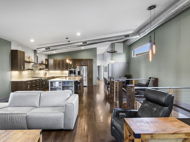 living room featuring dark wood-type flooring, vaulted ceiling, and sink