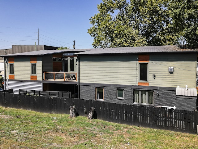 rear view of property featuring a lawn