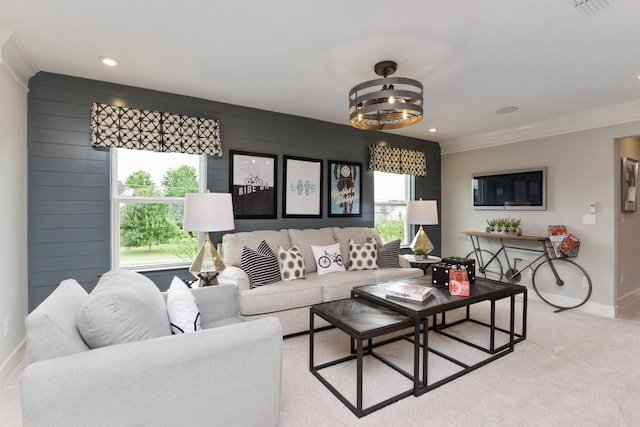 carpeted living room featuring a wealth of natural light, wood walls, and ornamental molding