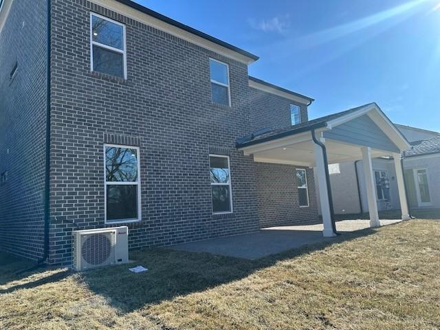 back of property featuring ac unit, a lawn, and a patio