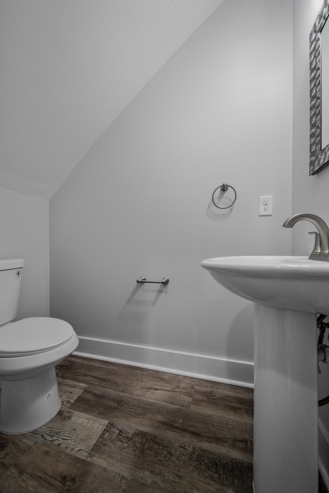 bathroom featuring vaulted ceiling, toilet, hardwood / wood-style floors, and sink