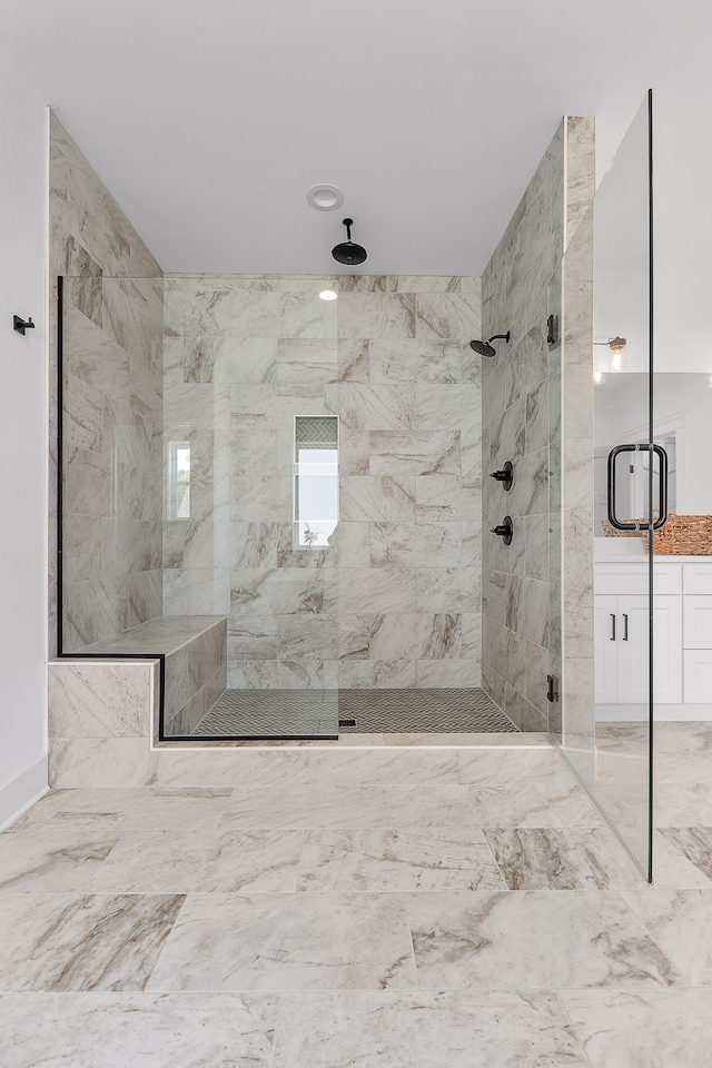 bathroom with a shower with door and vanity