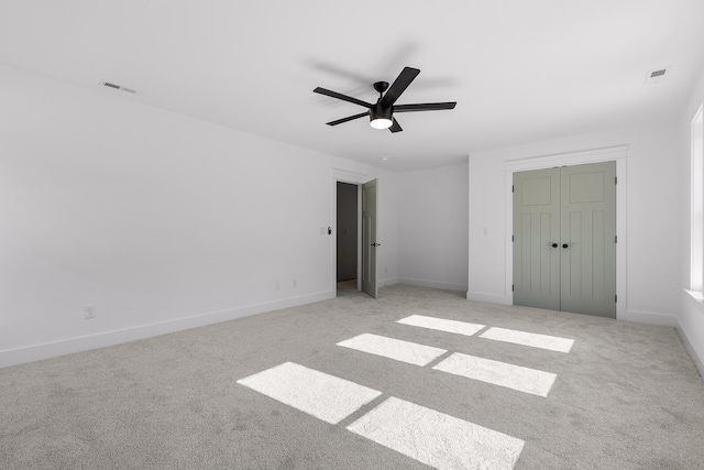 unfurnished bedroom featuring a closet, ceiling fan, and light carpet