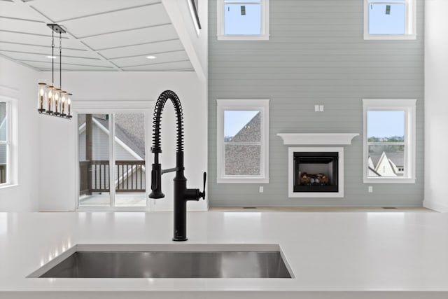 interior details featuring sink, decorative light fixtures, and wood walls