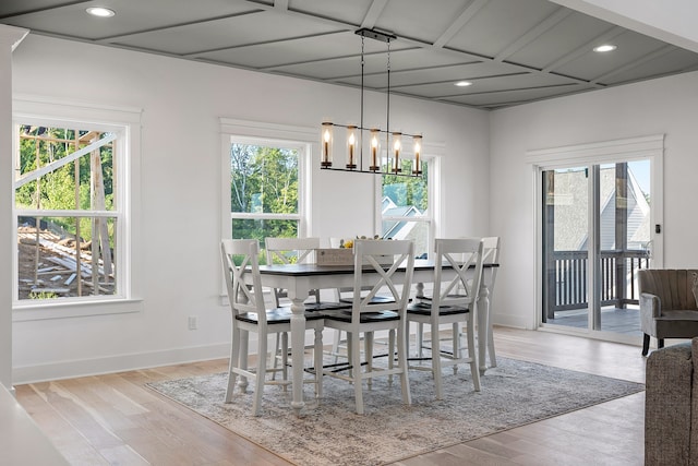 dining space with light hardwood / wood-style flooring, plenty of natural light, and an inviting chandelier