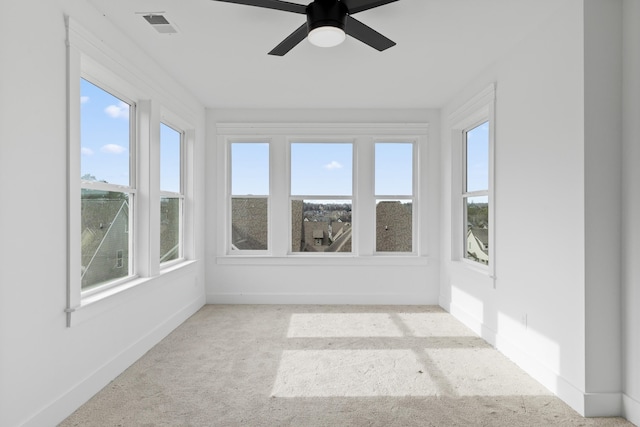 unfurnished sunroom featuring ceiling fan