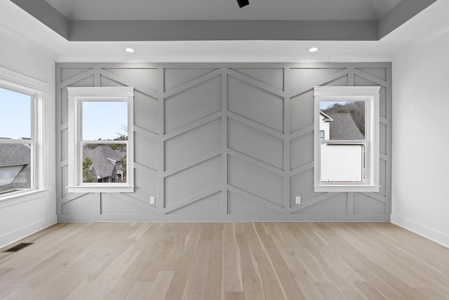 empty room featuring light hardwood / wood-style flooring and a raised ceiling