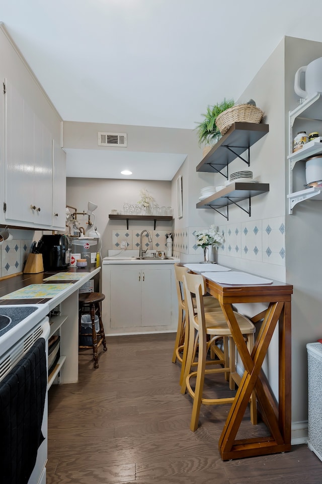 kitchen with white cabinetry, hardwood / wood-style floors, and backsplash