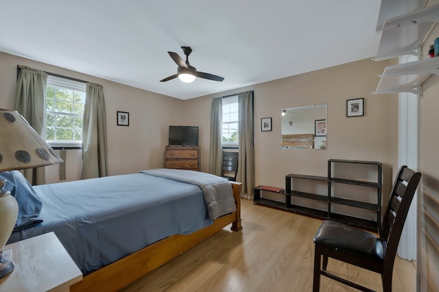 bedroom featuring multiple windows, light hardwood / wood-style flooring, and ceiling fan