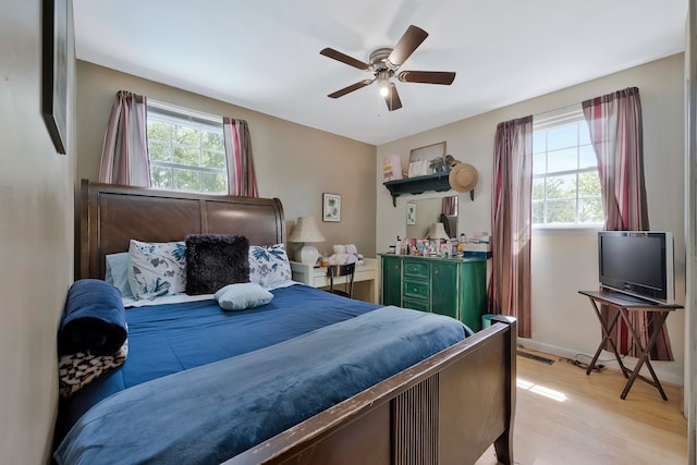 bedroom featuring multiple windows, ceiling fan, and light hardwood / wood-style floors