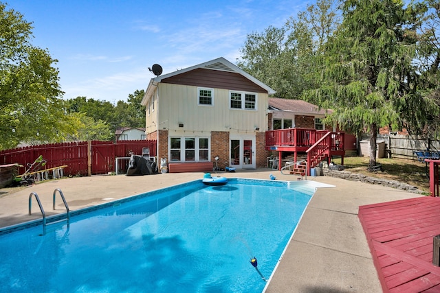 view of pool featuring a patio area, a deck, and french doors