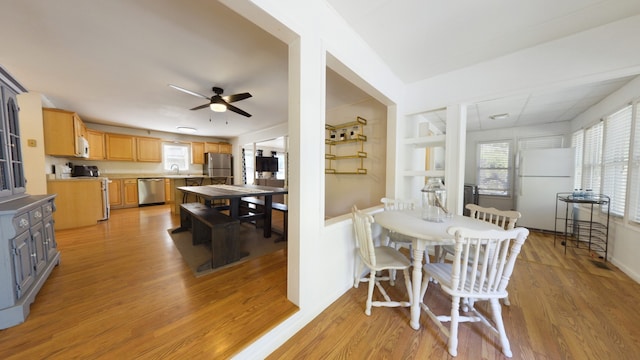 dining area with ceiling fan, light hardwood / wood-style floors, and sink