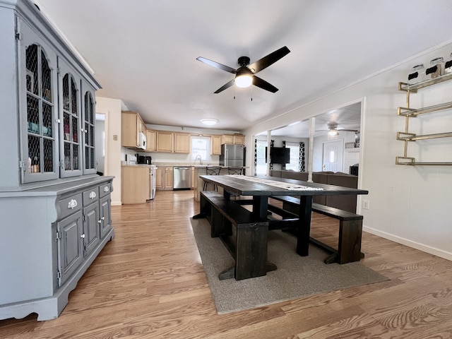 dining room with ornamental molding, hardwood / wood-style floors, sink, and ceiling fan