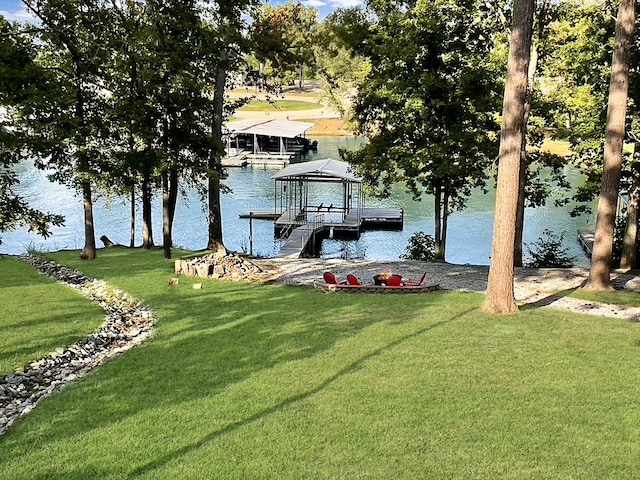 dock area with a water view and a yard