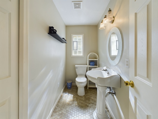 bathroom with toilet and tile patterned flooring