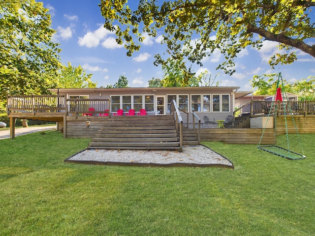 rear view of house featuring a yard, a sunroom, and a deck