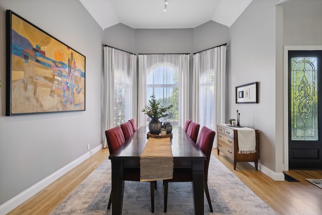 dining room featuring light hardwood / wood-style floors and lofted ceiling