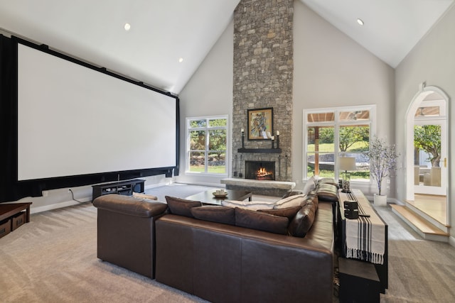 home theater room featuring light carpet, a fireplace, and high vaulted ceiling