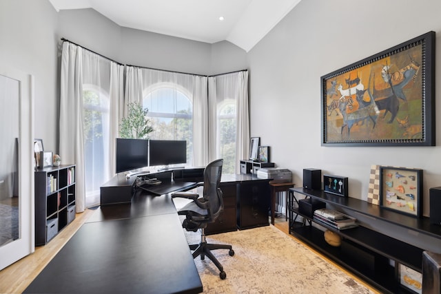 office area with light hardwood / wood-style flooring and vaulted ceiling