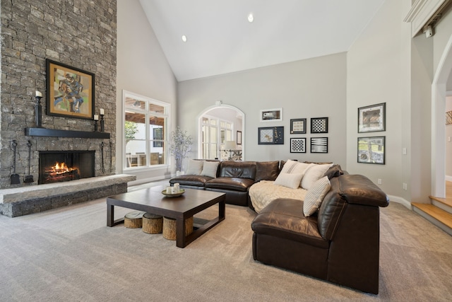 carpeted living room featuring a fireplace, high vaulted ceiling, and french doors