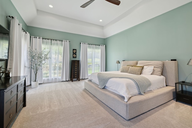 bedroom featuring a tray ceiling, ceiling fan, and light colored carpet