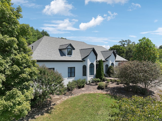 french provincial home with a front lawn