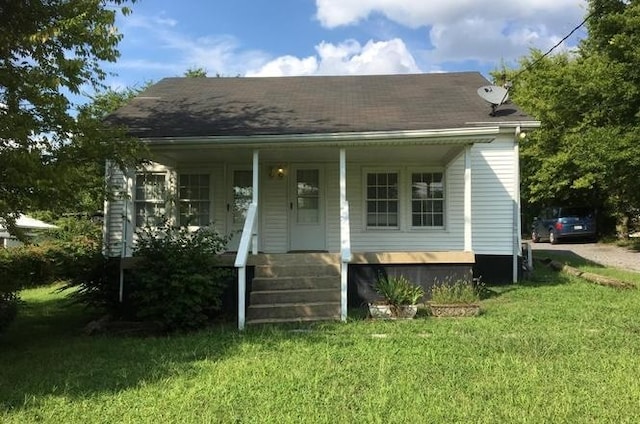 back of property featuring a porch and a lawn