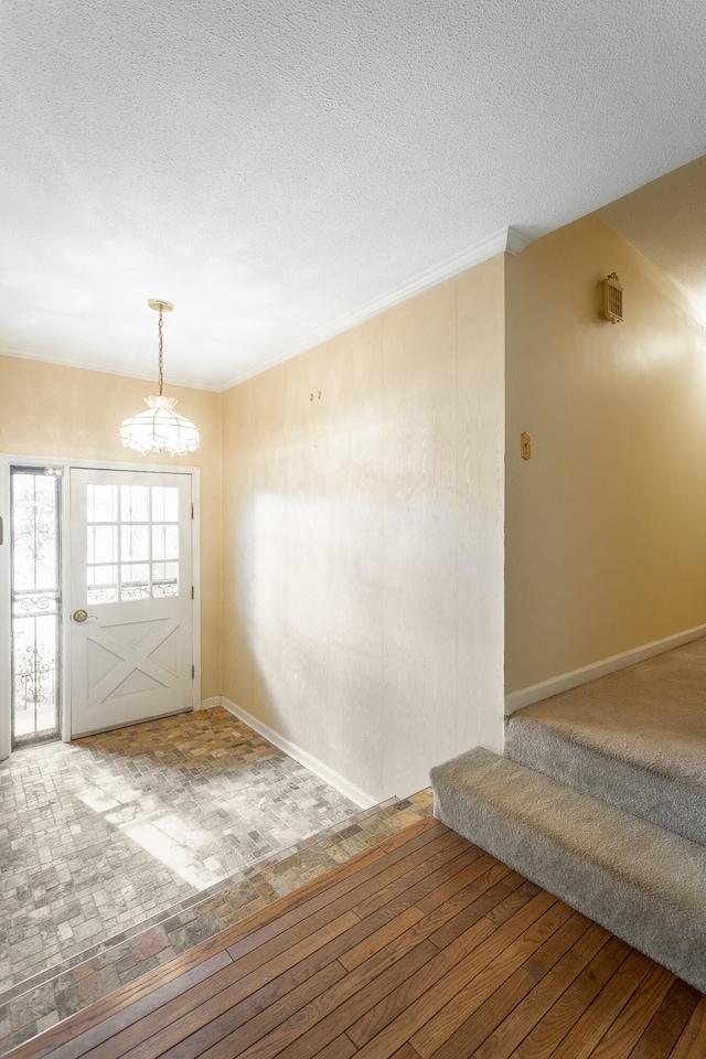 entryway featuring hardwood / wood-style flooring, a notable chandelier, and a textured ceiling