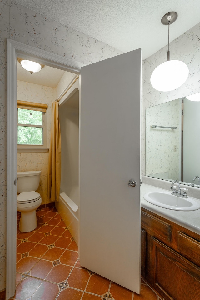 bathroom featuring a shower with shower curtain, tile patterned flooring, toilet, vanity, and a textured ceiling