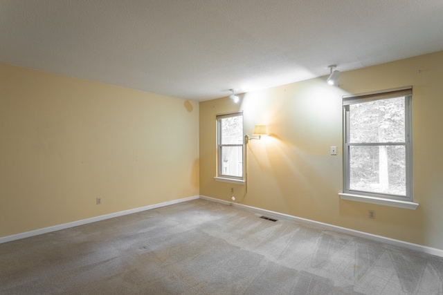 carpeted spare room with a textured ceiling