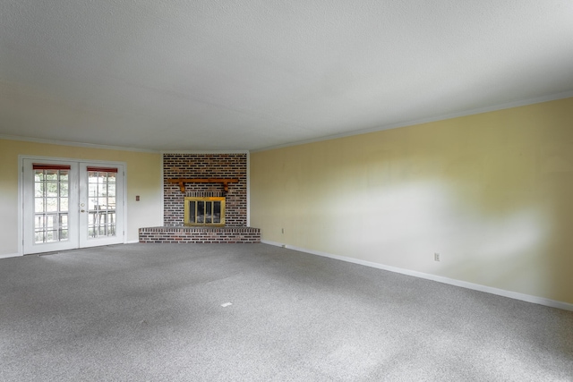 unfurnished living room with a textured ceiling, carpet, ornamental molding, and a fireplace