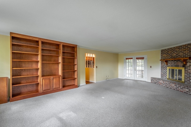 unfurnished living room featuring a textured ceiling, ornamental molding, carpet floors, and a fireplace