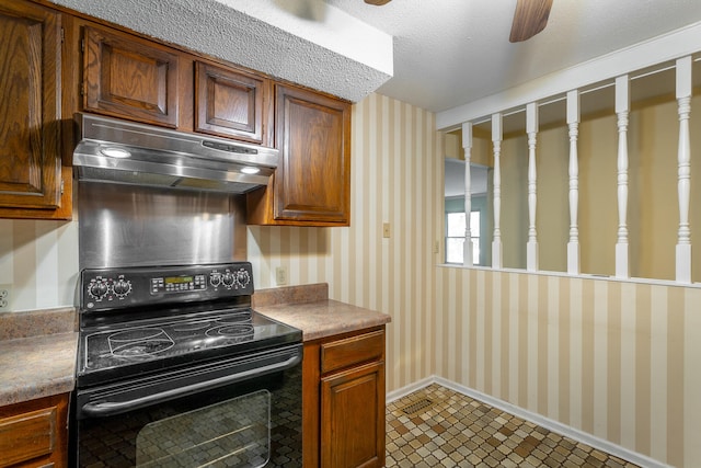 kitchen with ceiling fan, electric range, and a textured ceiling