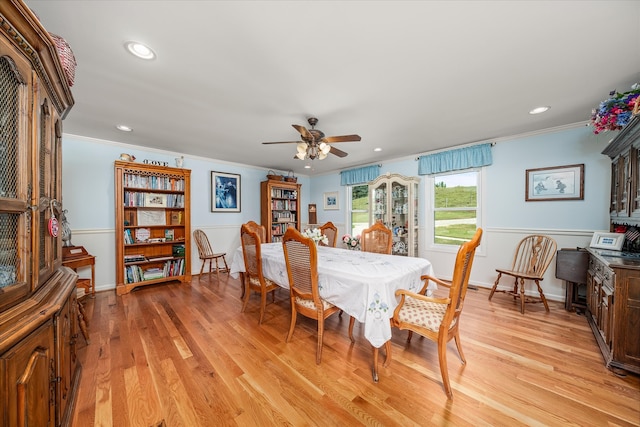 dining room with light wood-type flooring, ceiling fan, and crown molding