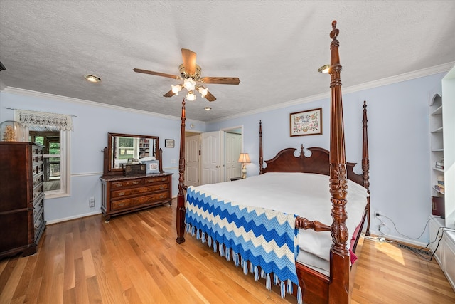 bedroom featuring a textured ceiling, light wood-type flooring, ornamental molding, and ceiling fan