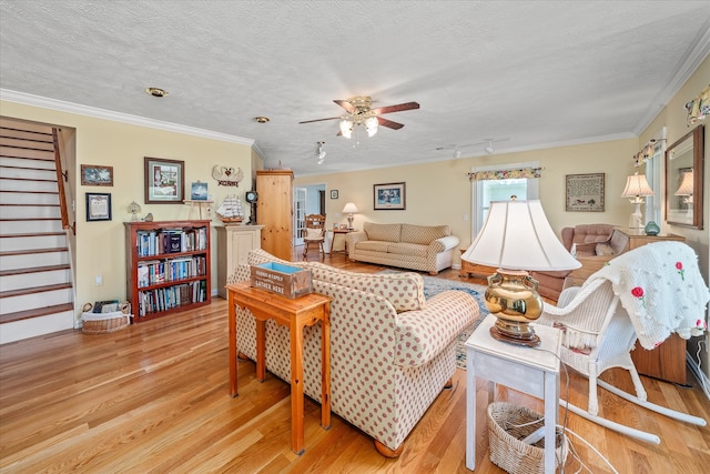 living room with a textured ceiling, light hardwood / wood-style floors, and crown molding