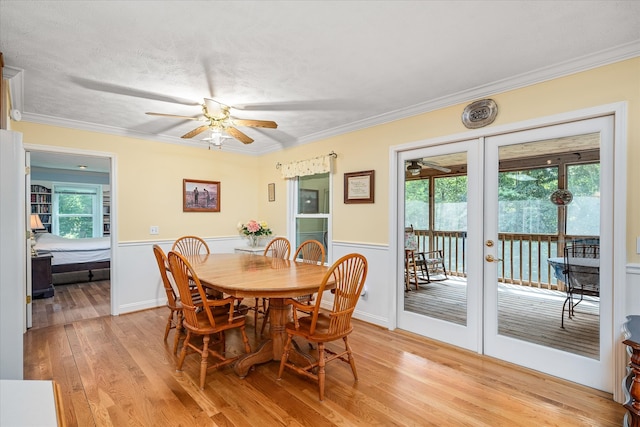 dining area featuring ornamental molding, french doors, ceiling fan, and light hardwood / wood-style flooring