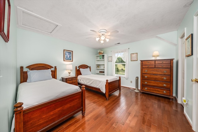 bedroom with dark wood-type flooring, a textured ceiling, and ceiling fan