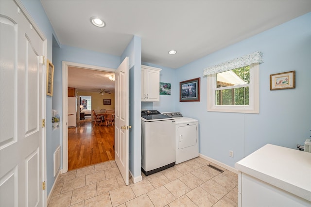 clothes washing area with washer and clothes dryer, light wood-type flooring, cabinets, and ceiling fan