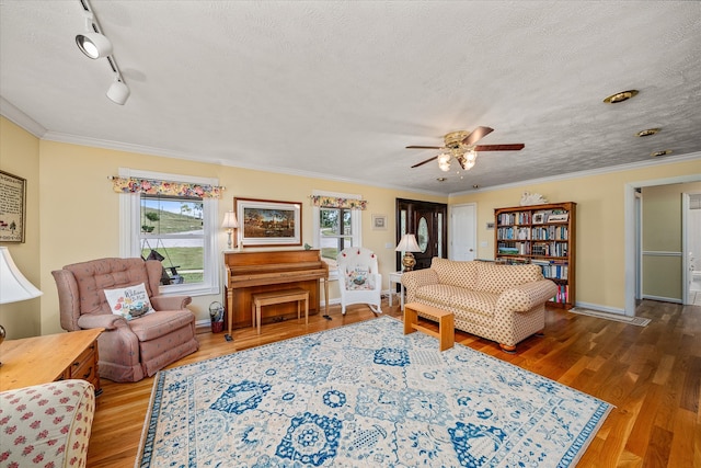 living room with hardwood / wood-style floors, a textured ceiling, and crown molding