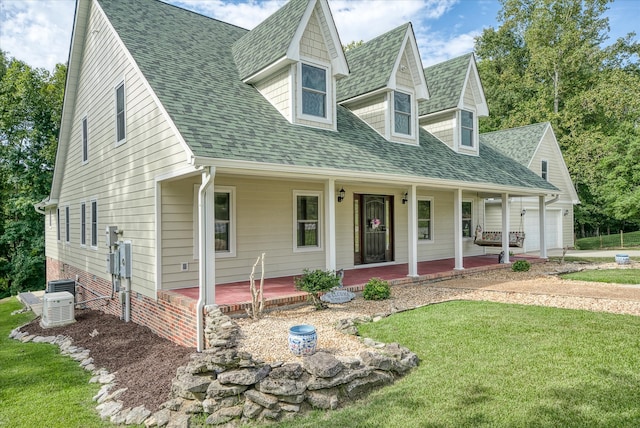 cape cod home featuring a garage, central AC, covered porch, and a front yard