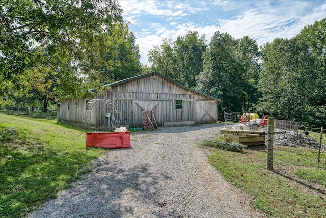 view of side of property with a yard and an outdoor structure