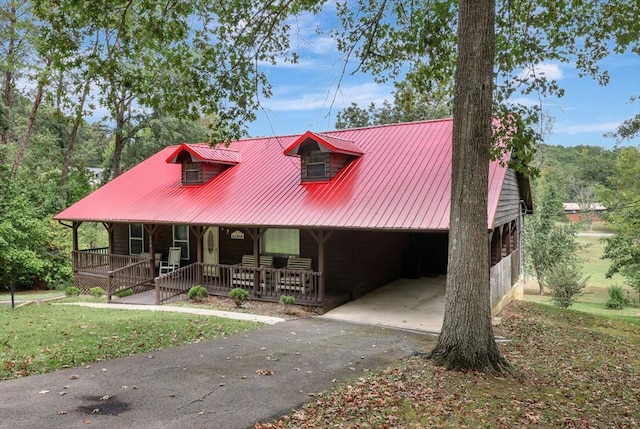 view of front of property with a front lawn, covered porch, and a carport